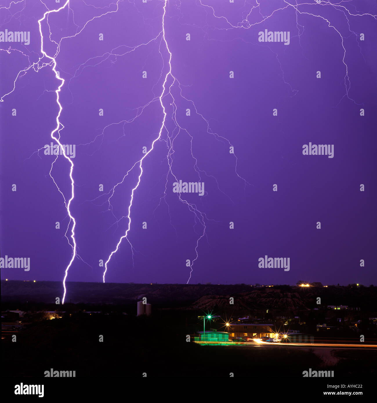 Lightning bolts strike during an unusual winter thunderstorm in Benson Arizona United States with city lights in the foreground. Stock Photo