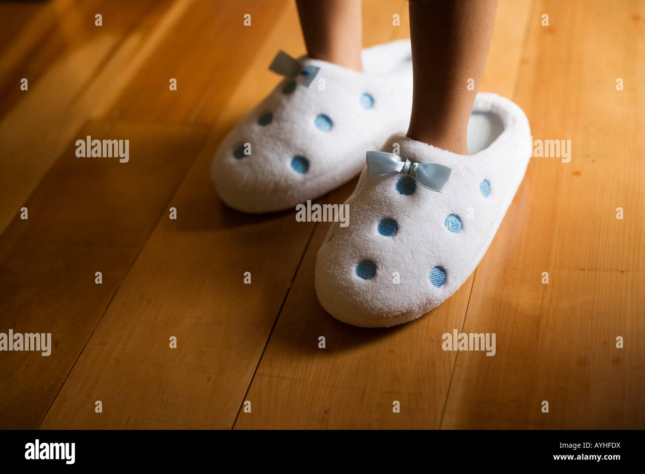 Girl aged four wears her mother s slippers Stock Photo