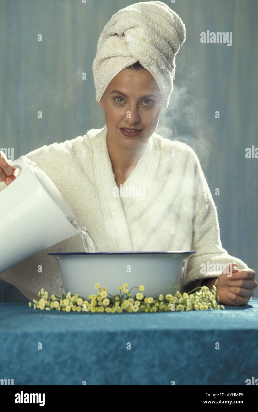 Frau brueht sich Kamillen Dampfbad auf Stock Photo