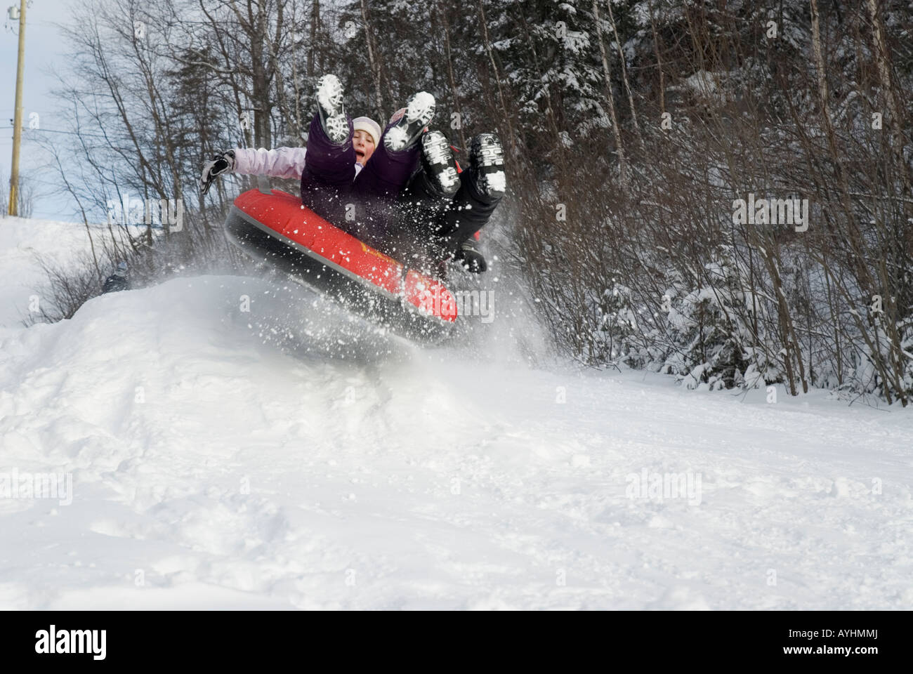 Children tubing down hill over jump Stock Photo Alamy