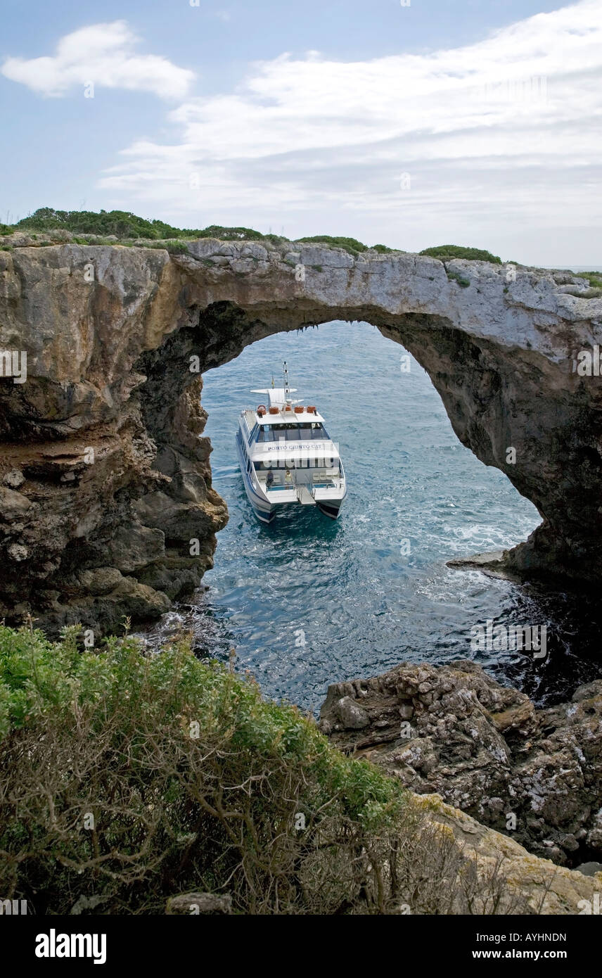 Tourist boat and natural stone arch.Near Porto Cristo.Mallorca Island.Spain Stock Photo