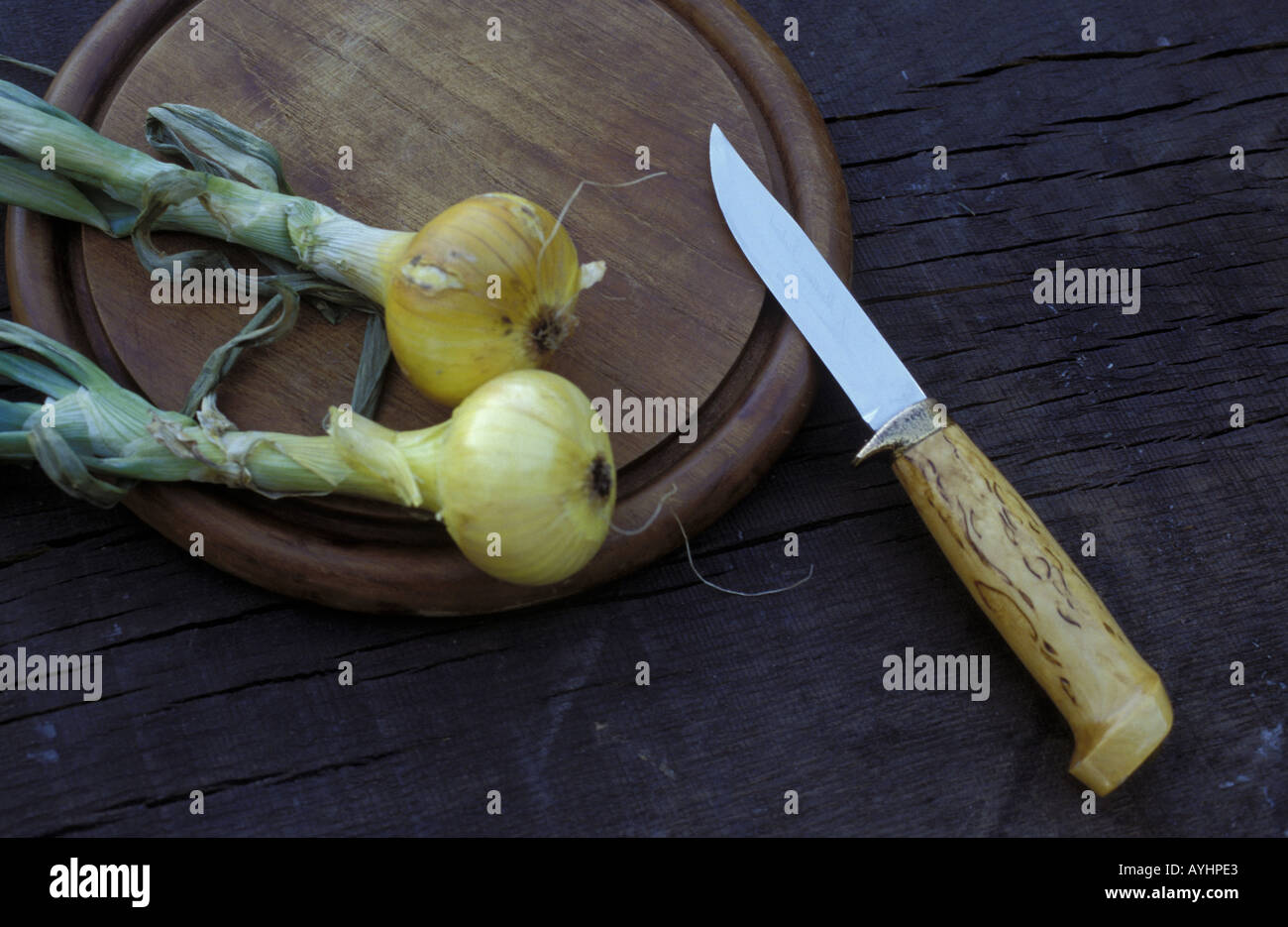 Holzbrett mit Messer und zwei Zwiebeln Stock Photo
