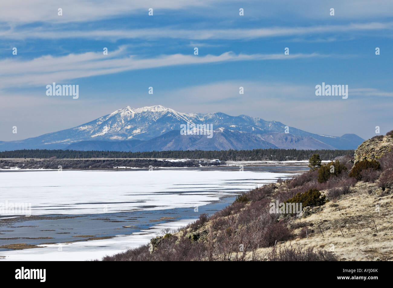 Looking across a frozen Mormon Lake towards the San Francisco Peaks near Flagstaff, Arizona Stock Photo