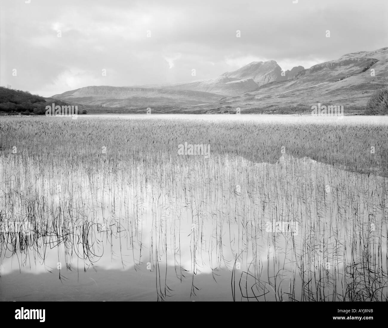 Distant hills are reflected in the still waters of Loch Cill Chriosd with Blaven in the distance, Isle of Skye, Scotland Stock Photo