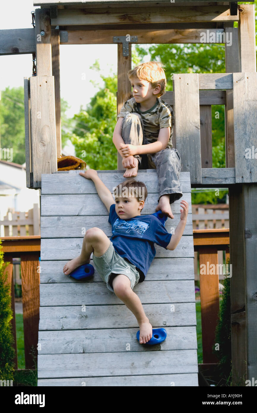 Boys age 5 sitting on climbing ramp. St Paul Minnesota USA Stock Photo