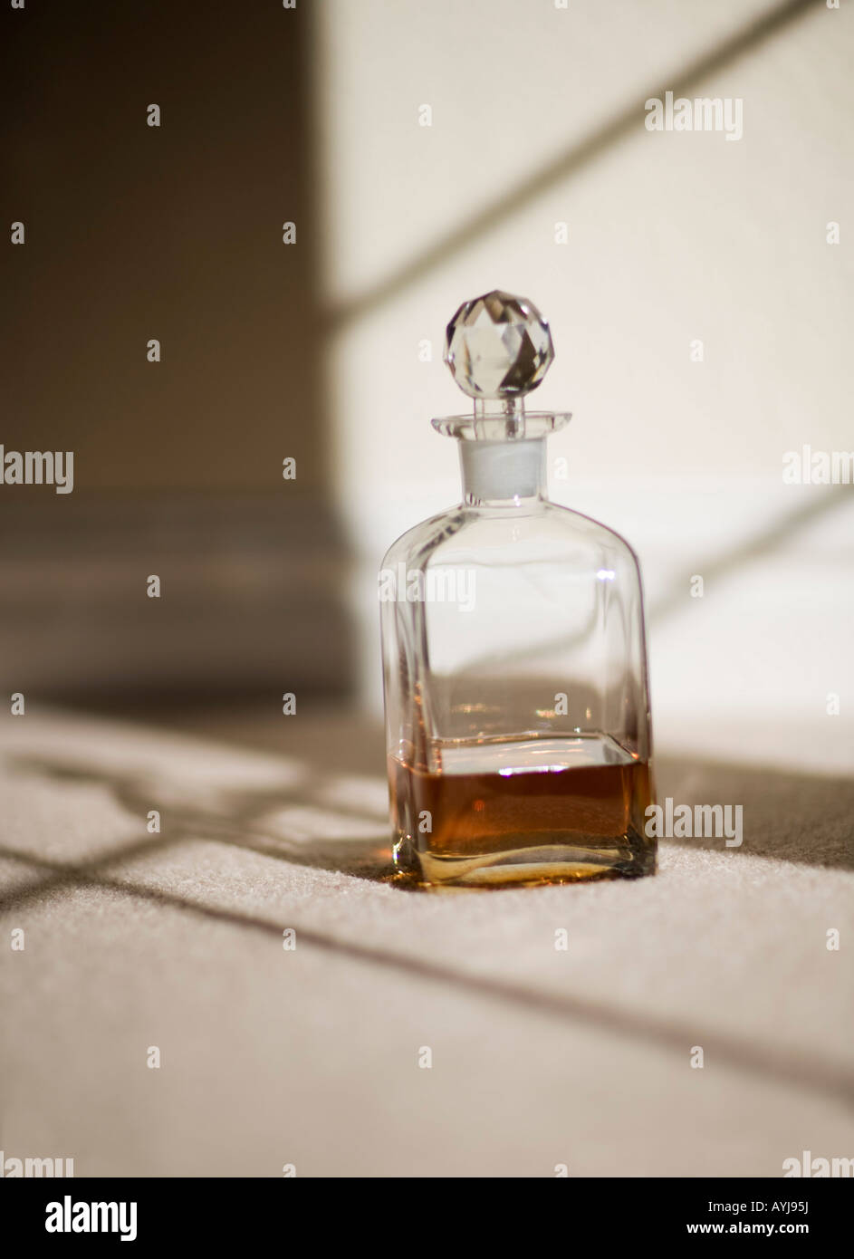 glass bottle of whisky by window Stock Photo