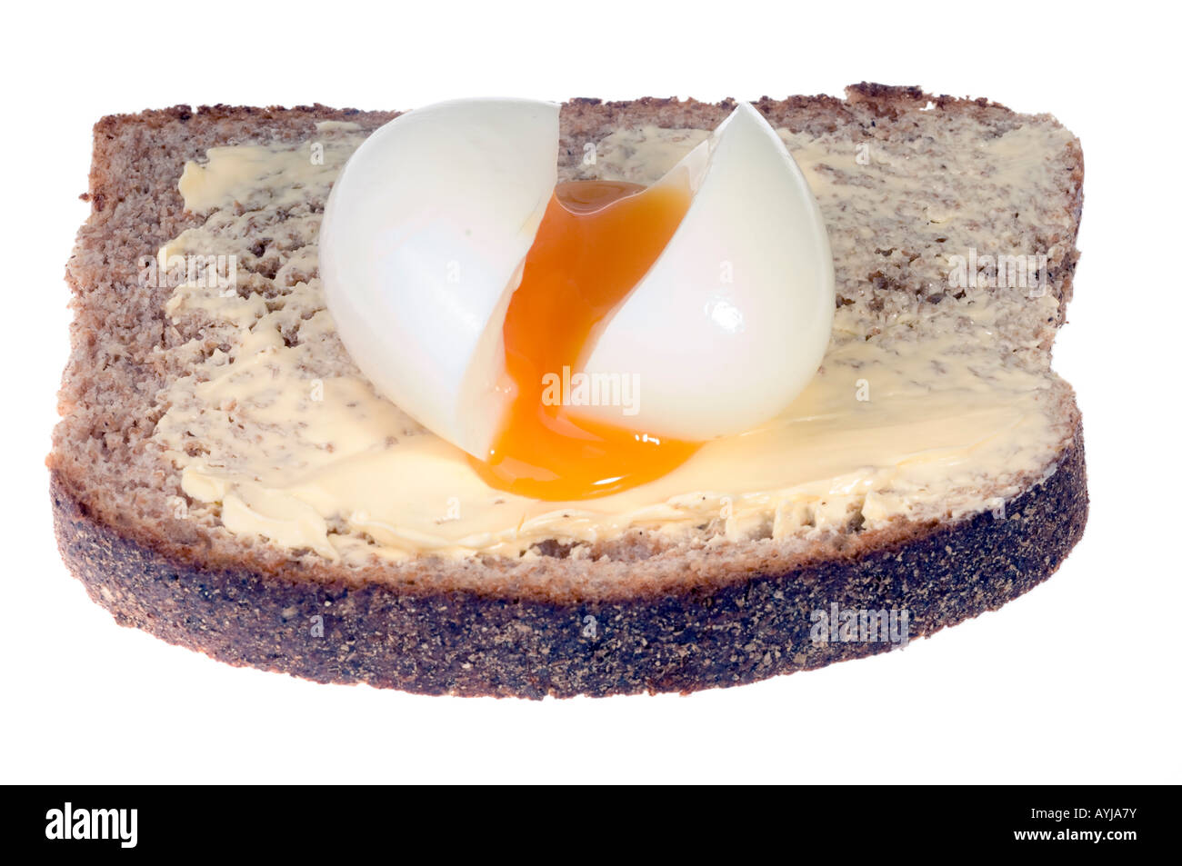 A shelled runny boiled egg on buttered wholemeal bread Stock Photo