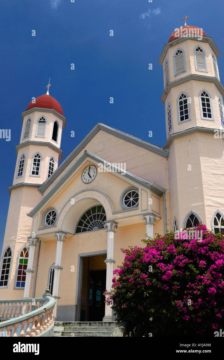 Church of San Rafael in Zarcero Costa Rica with flowering Bouganvilla bush and twin towers Stock Photo
