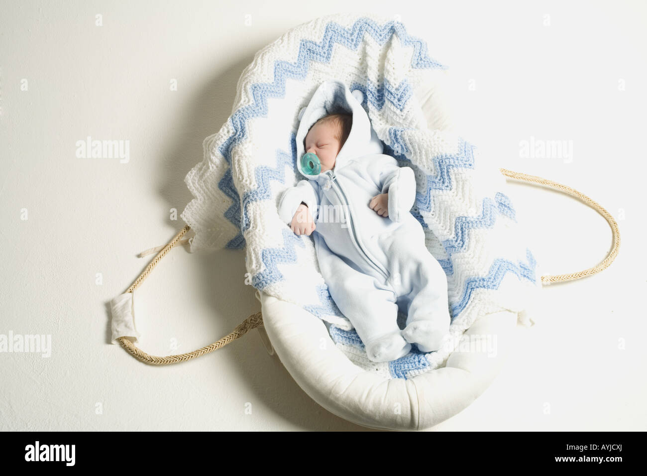 A baby sleeping in a bassinet with a pacifier. Stock Photo