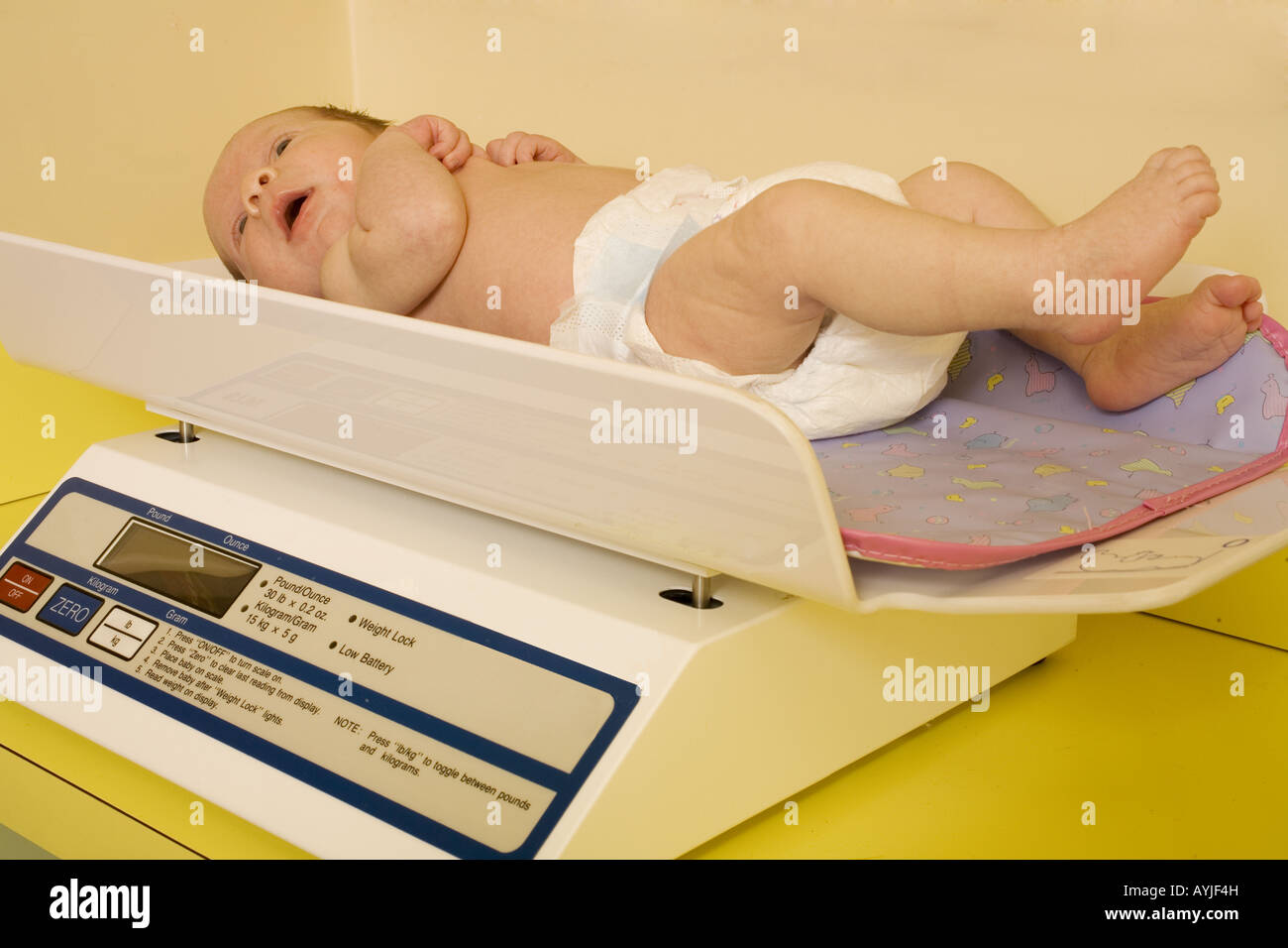 https://c8.alamy.com/comp/AYJF4H/a-baby-being-weighed-on-a-scale-in-an-exam-at-the-pediatric-doctor-AYJF4H.jpg