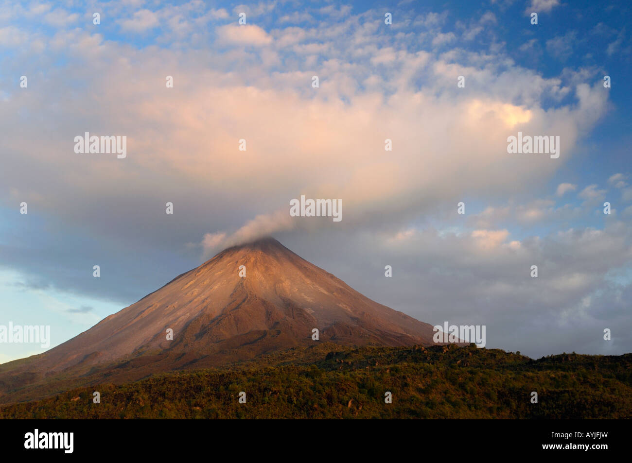 Gold light on Cloud expanding from smoke of Arenal Volcano vent  Costa Rica at sunset Stock Photo