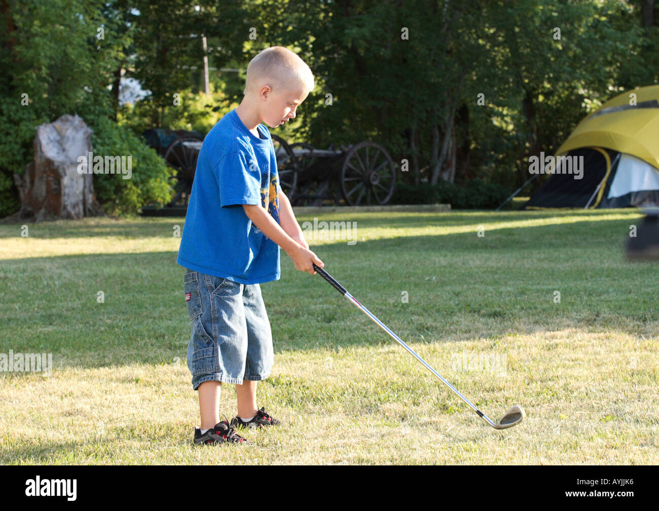 young boy prepares to hit golf ball Stock Photo