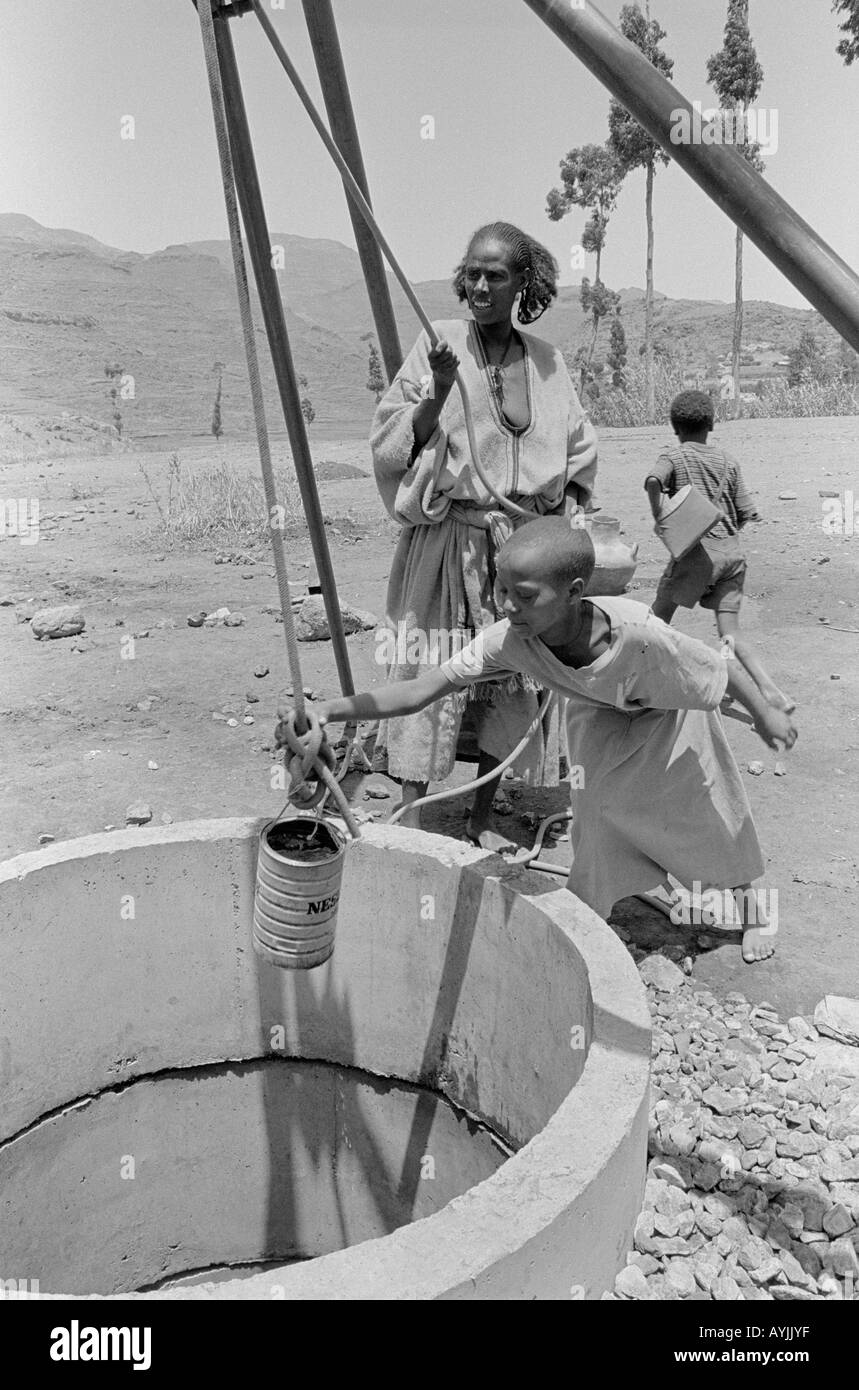 B/W of a Tigrayan woman and children lifting clean drinking water from a new, hand-dug well. Tigray, Ethiopia Stock Photo