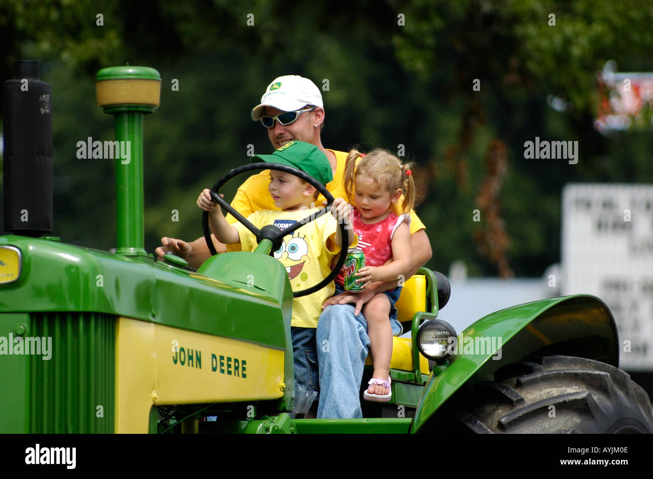 Father With Young Son And Daughter On John Deere Tractor Stock Photo