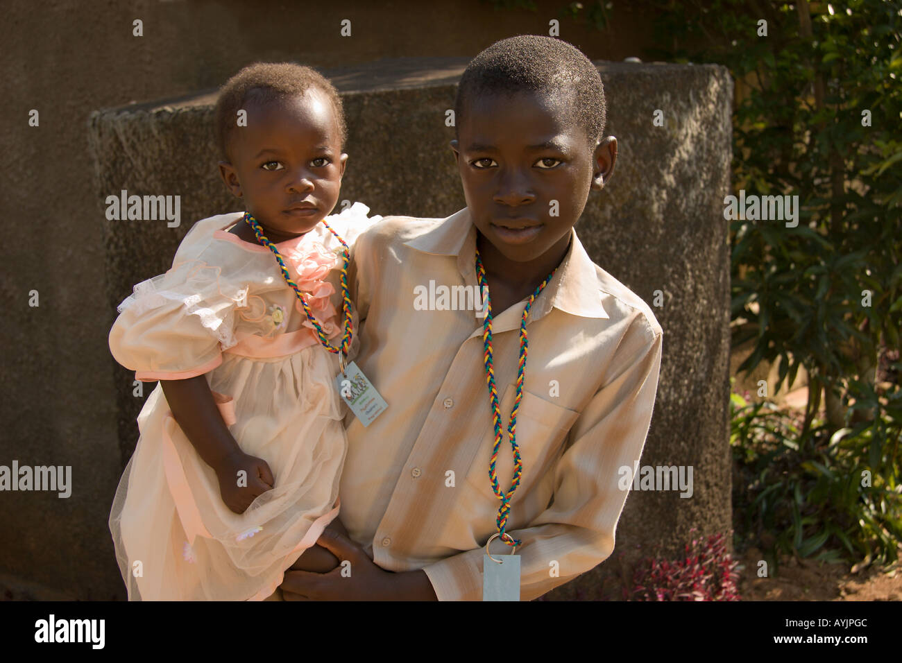 HIV Aids victims, caring brother carries his baby sister to Mildmay Centre Kalangala Uganda for screening and treatment Stock Photo