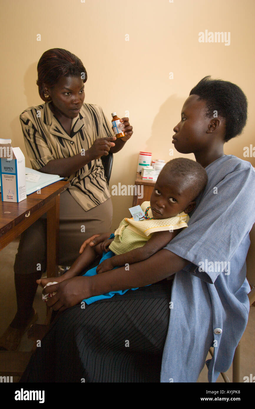 Nurse Farida supplies HIV-Aids drugs for victim Kirabira age 3 at Mildmay Centre Kalangala Uganda Stock Photo