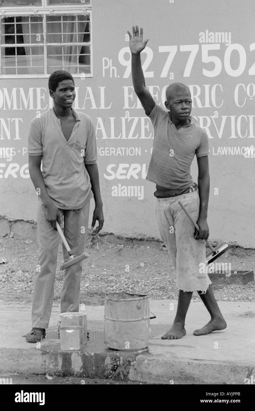 B/W of two street boys hailing cars for their windshield washing service on the streets of Kingston. Jamaica Stock Photo