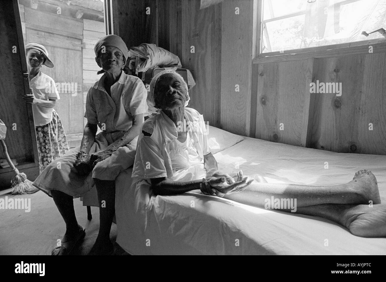 B/W portrait of a woman looking after her elderly mother in their home in the poorest part of Spanish Town, Jamaica Stock Photo