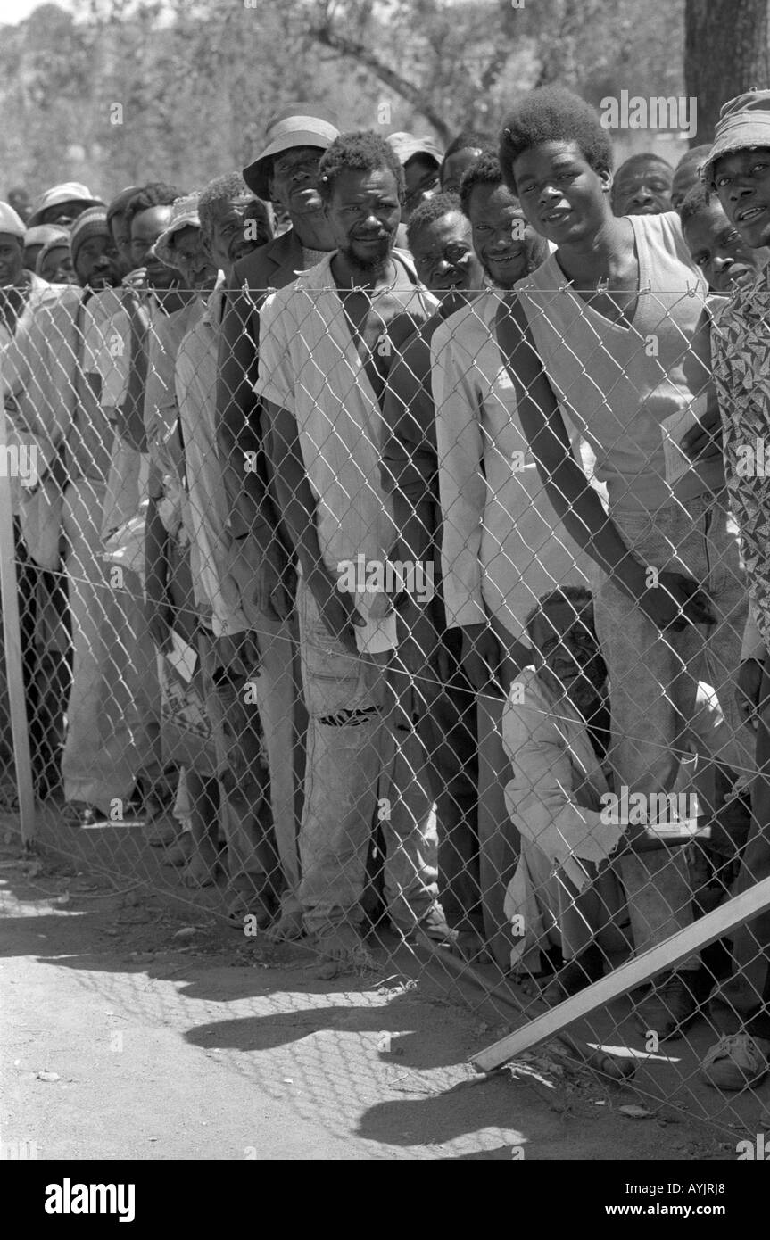 B/W of men waiting in line for food aid at a distribution center during a time of drought.Zaka, Zimbabwe Stock Photo