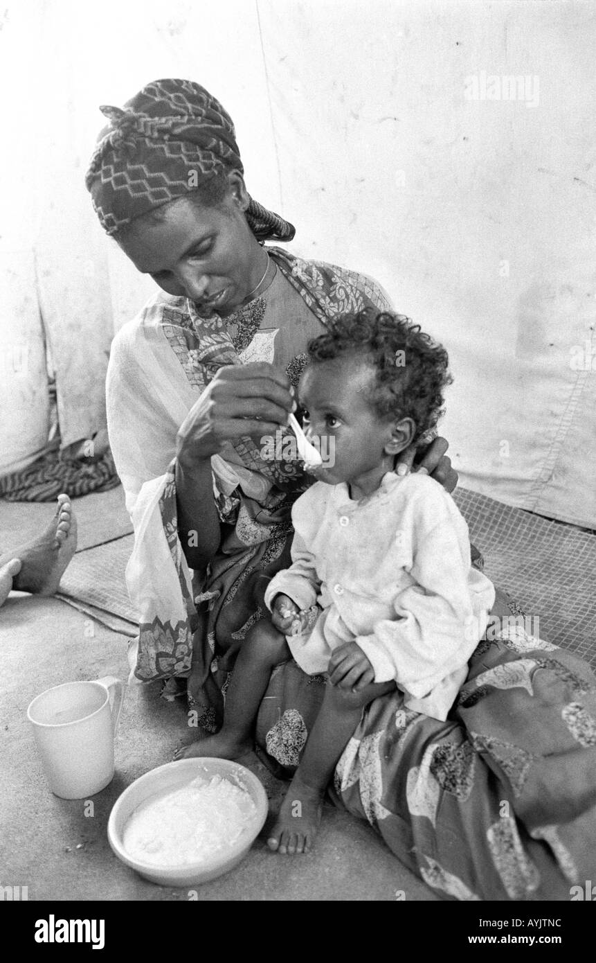 B/W of a Somali woman refugee feeding her malnourished child in an emergency feeding centre on the border with Somalia. Kebrebeyah, Ethiopia, Africa Stock Photo