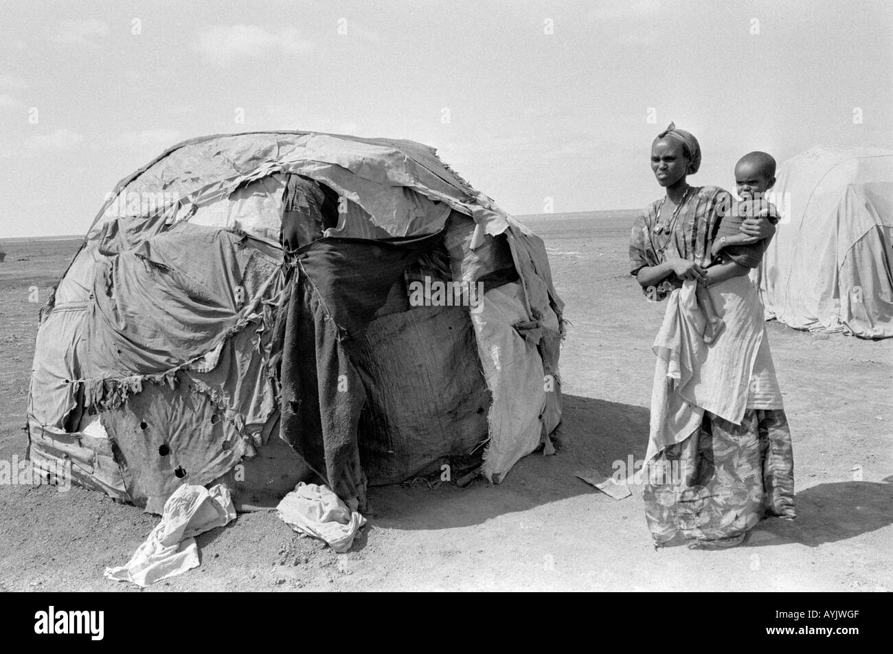 B/W of a Somali mother and child standing by their makeshift bender on the edge of Kebrebeyah refugee camp on the Somali border. Ethiopia, Africa Stock Photo