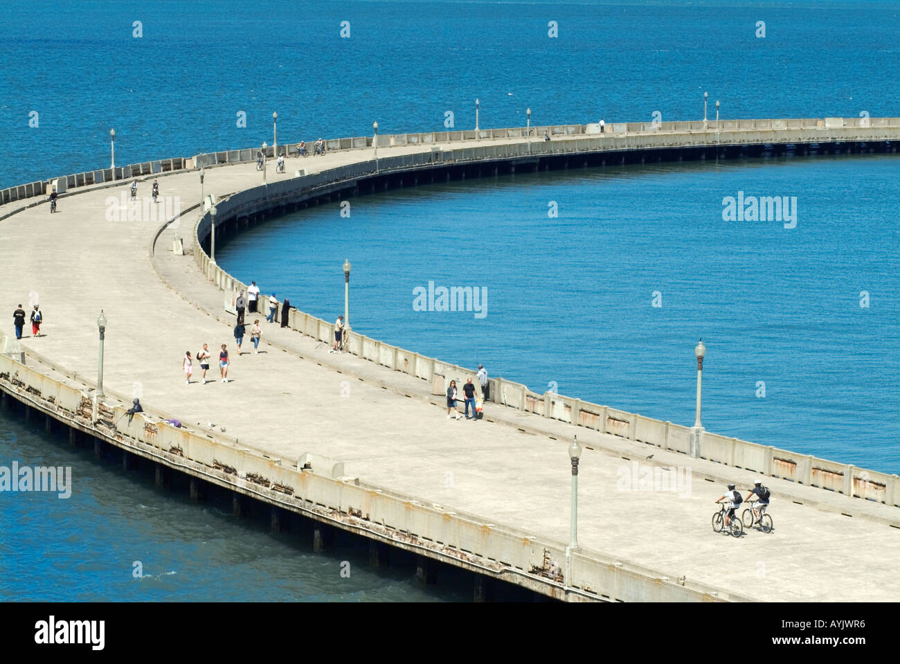People walking on curved road Stock Photo