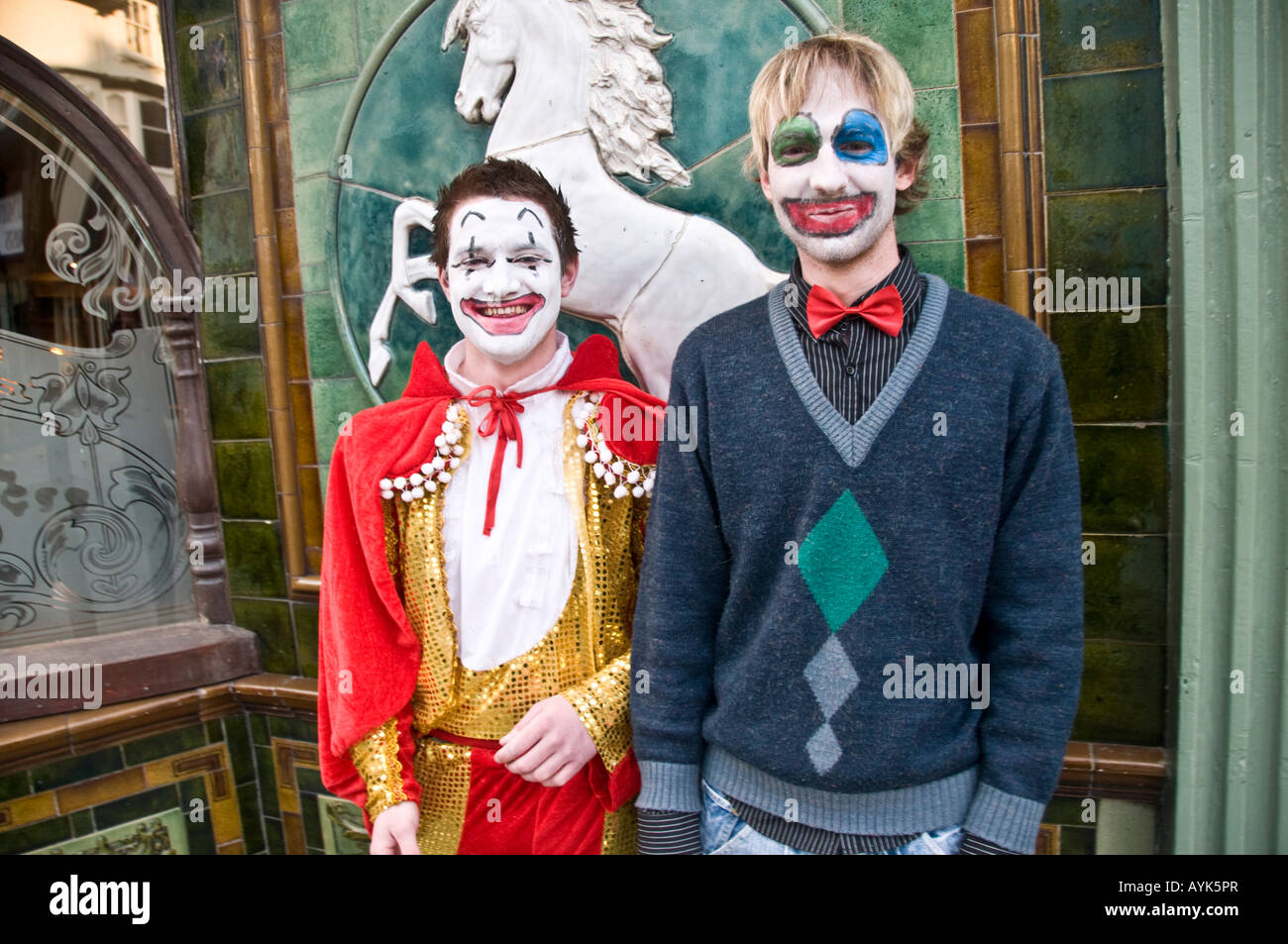 Two men with faces painted as clowns standing outside a pub in Aberystwyth Wales Stock Photo
