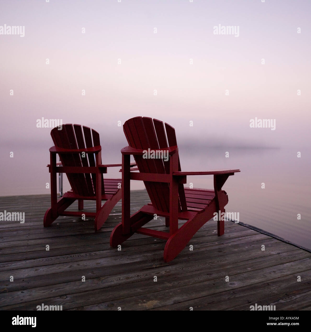 Lake of the Woods, Ontario, Canada, Two red Adirondack chairs on a dock