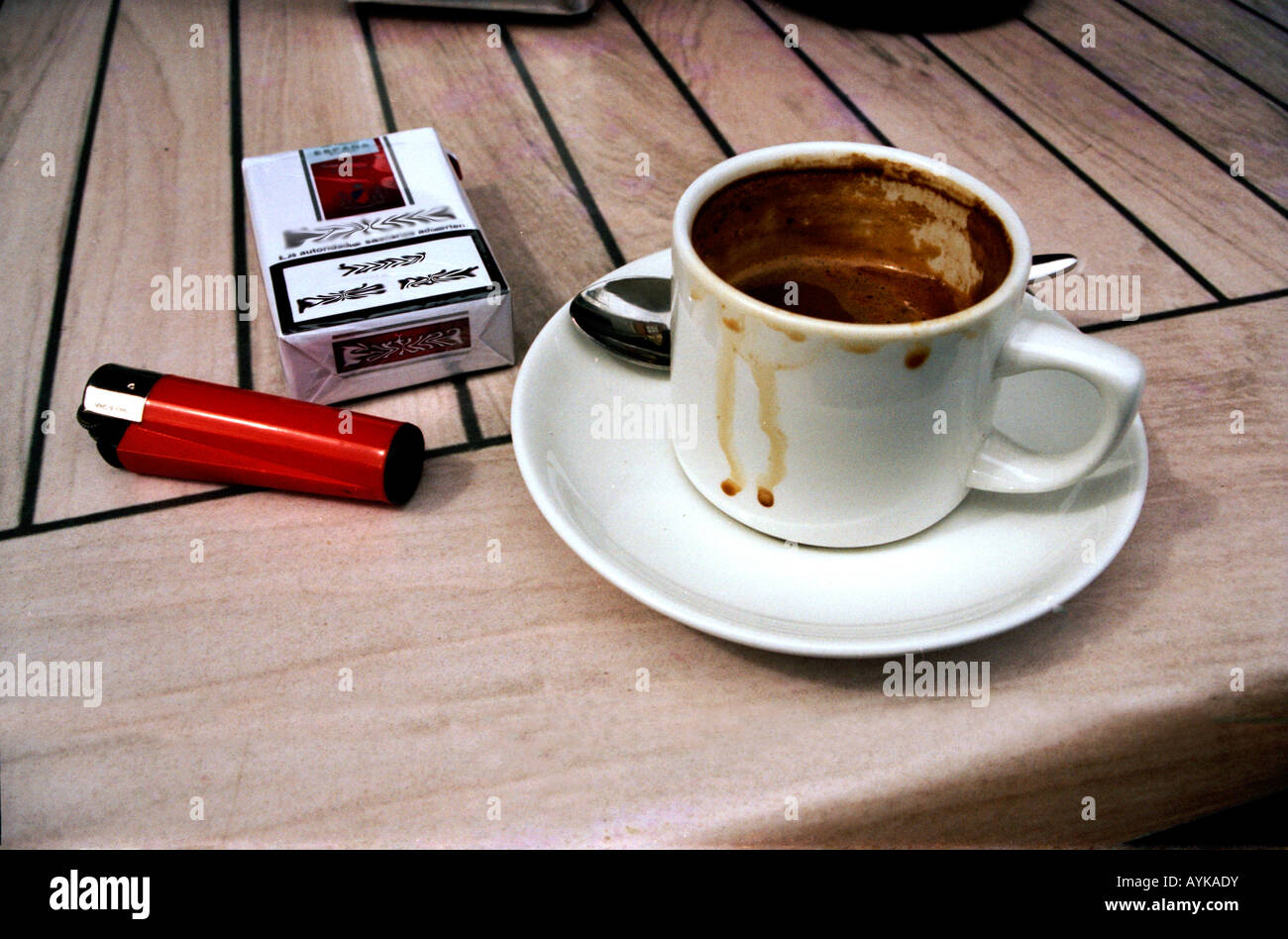 Coffee cup cigarettes and lighter on cafe table Stock Photo