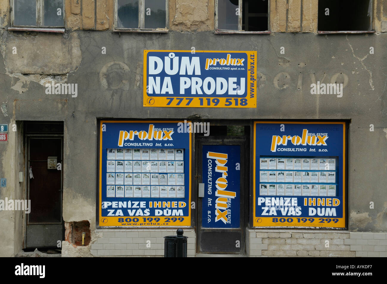 An estate agent advertising properties in a shop window of an old ramshackled house on a shopping street in Decin Czech Rep 44pi Stock Photo