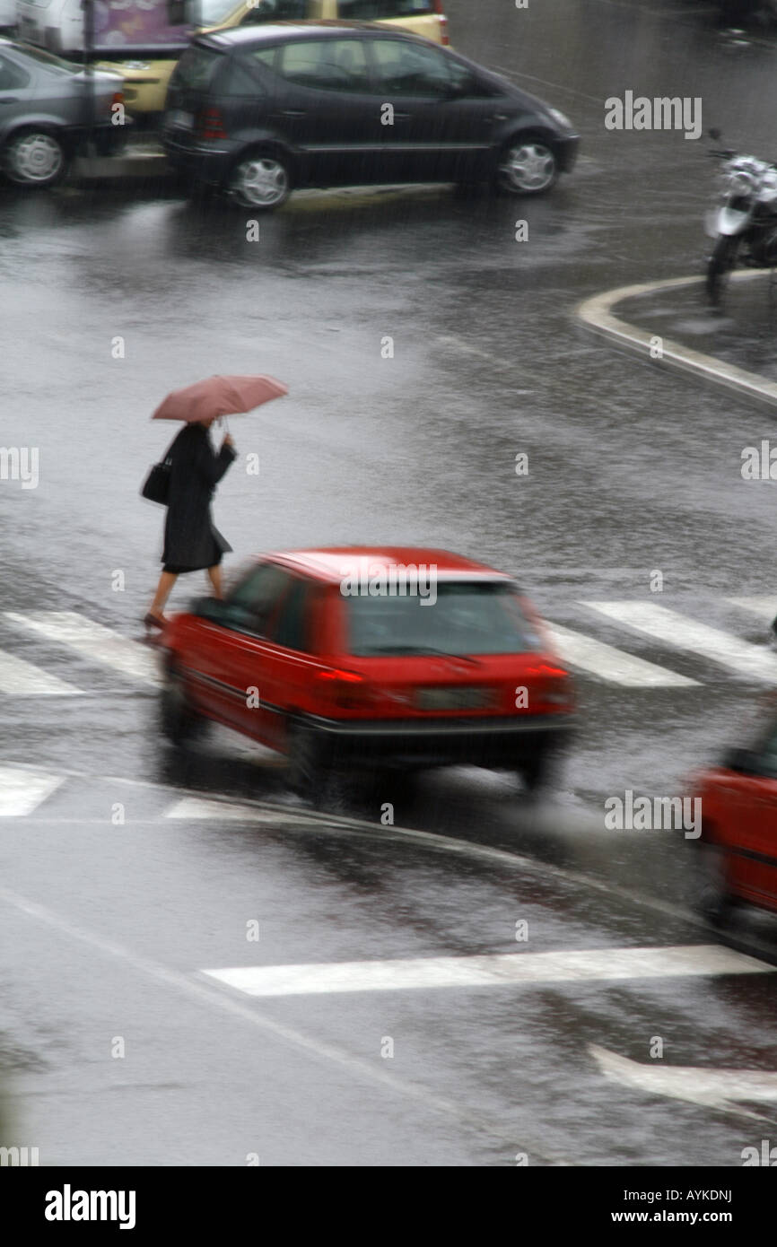 woman with umbrella crossing road in rain Stock Photo - Alamy