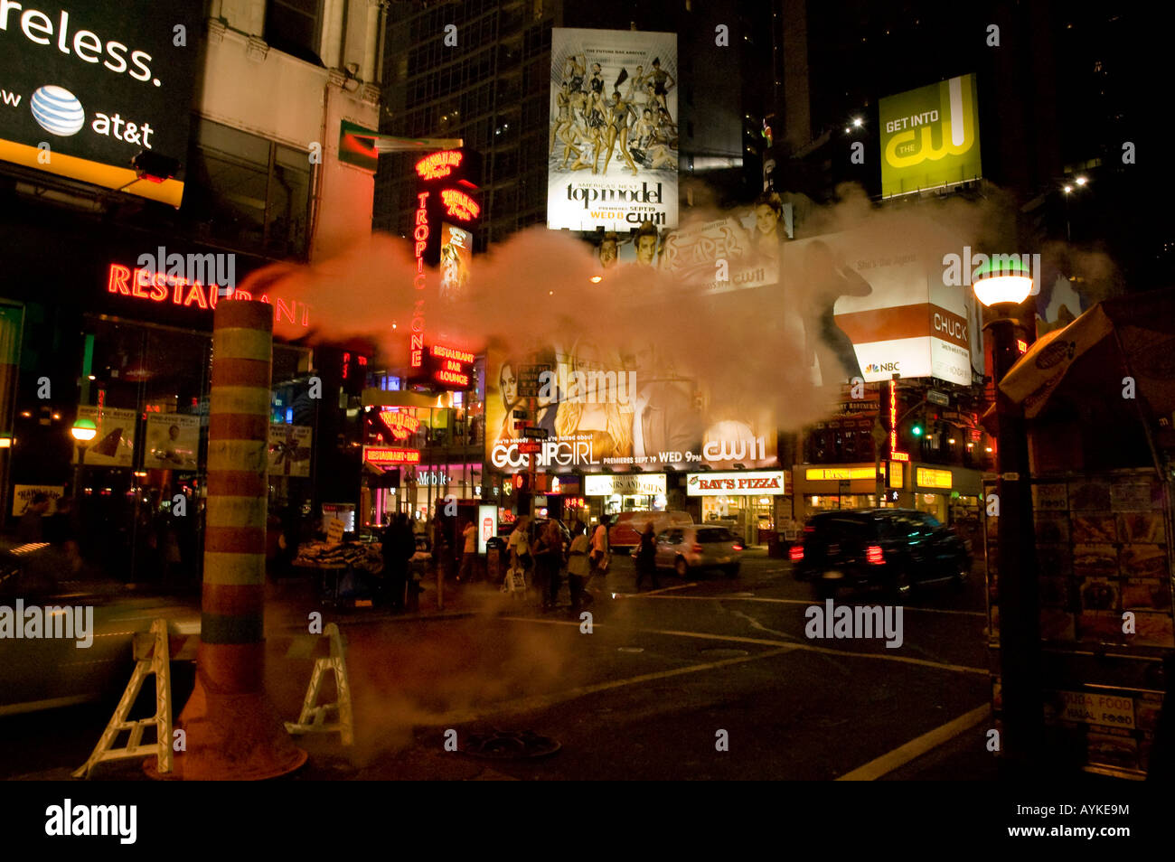 pipe blowing out steam on the streets of New York City at night, giving