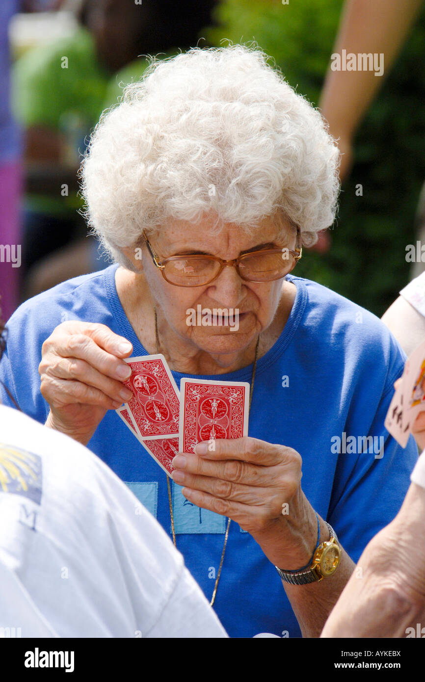 Senior female playing cards at a summertime seniors party Stock Photo