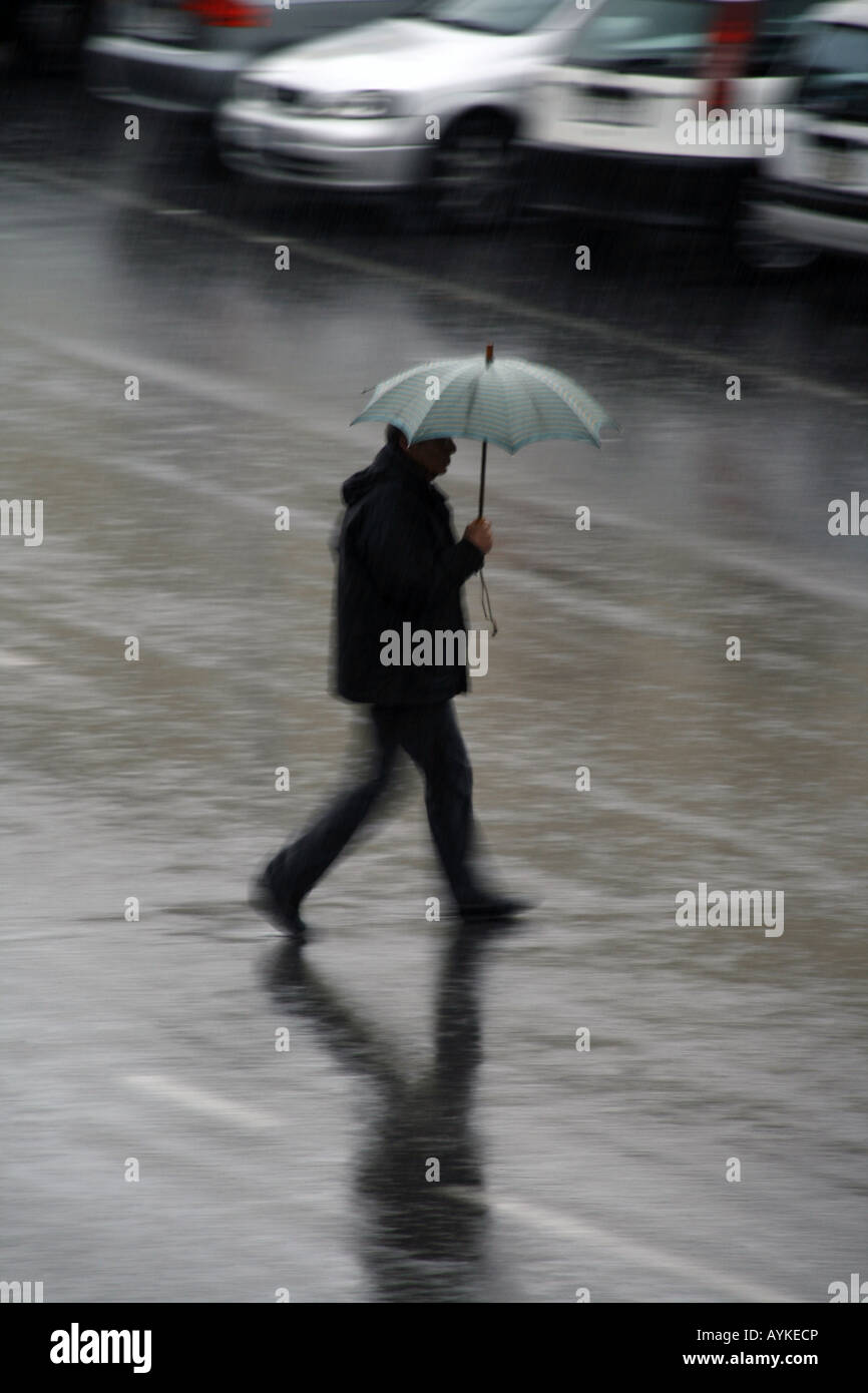 man walking with umbrella in rain Stock Photo Alamy