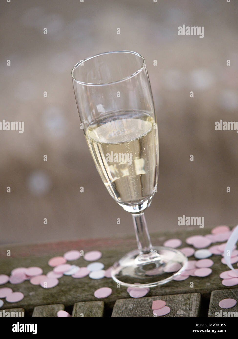 Champagne glass on wooden table with confetti pastel colours wedding celebration Stock Photo