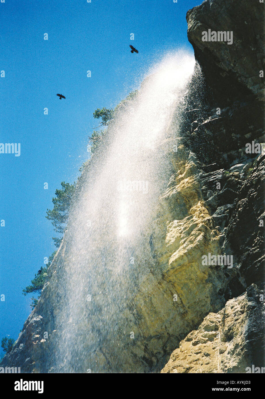 Voegel kreisen ueber einem Wasserfall Oeschinensee Schweiz Stock Photo