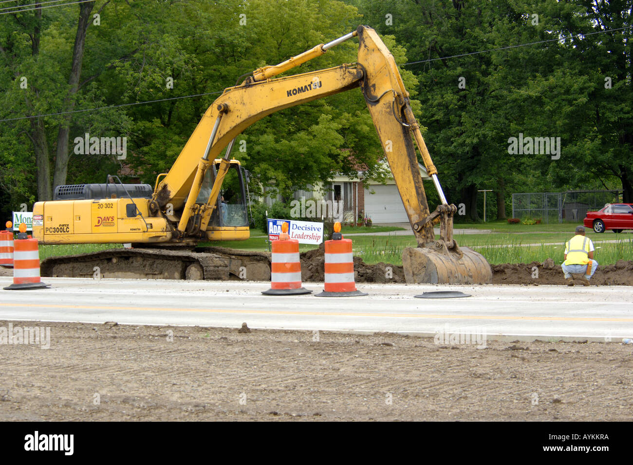 A yellow excavator digging a drainage trench Stock Photo - Alamy
