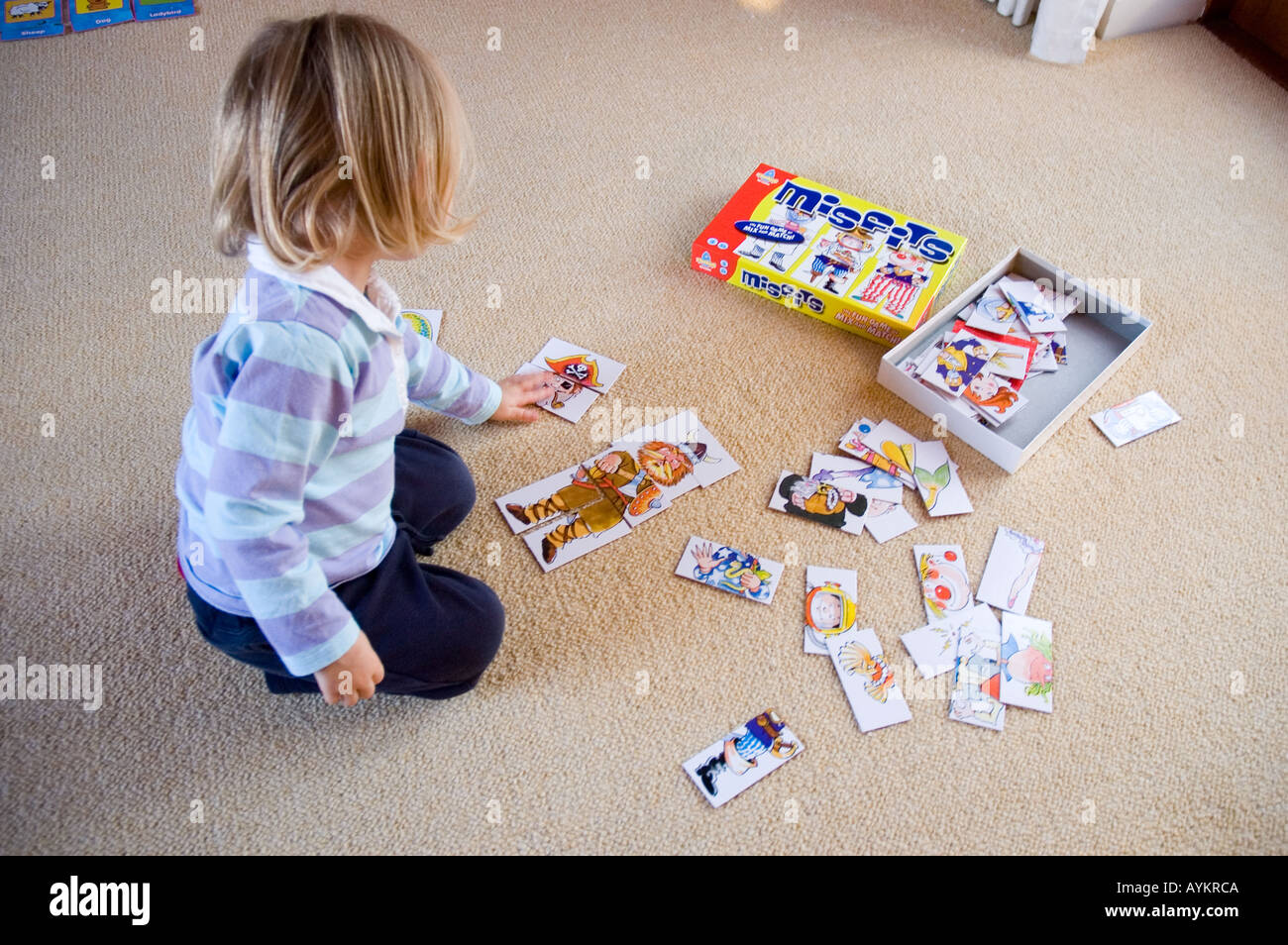 Toddler playing 'Misfits' - a game of matching parts Stock Photo