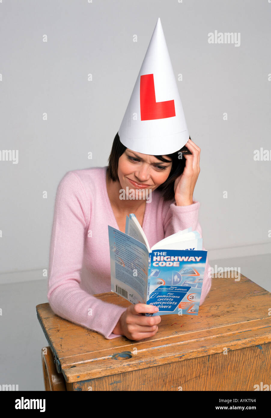 learner driver at her desk struggles with her highwaycode theory test ...