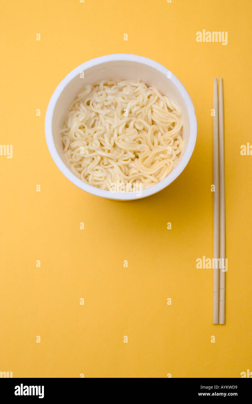 bowl of instant noodles and chopsticks on table concept busy overtime rush Stock Photo
