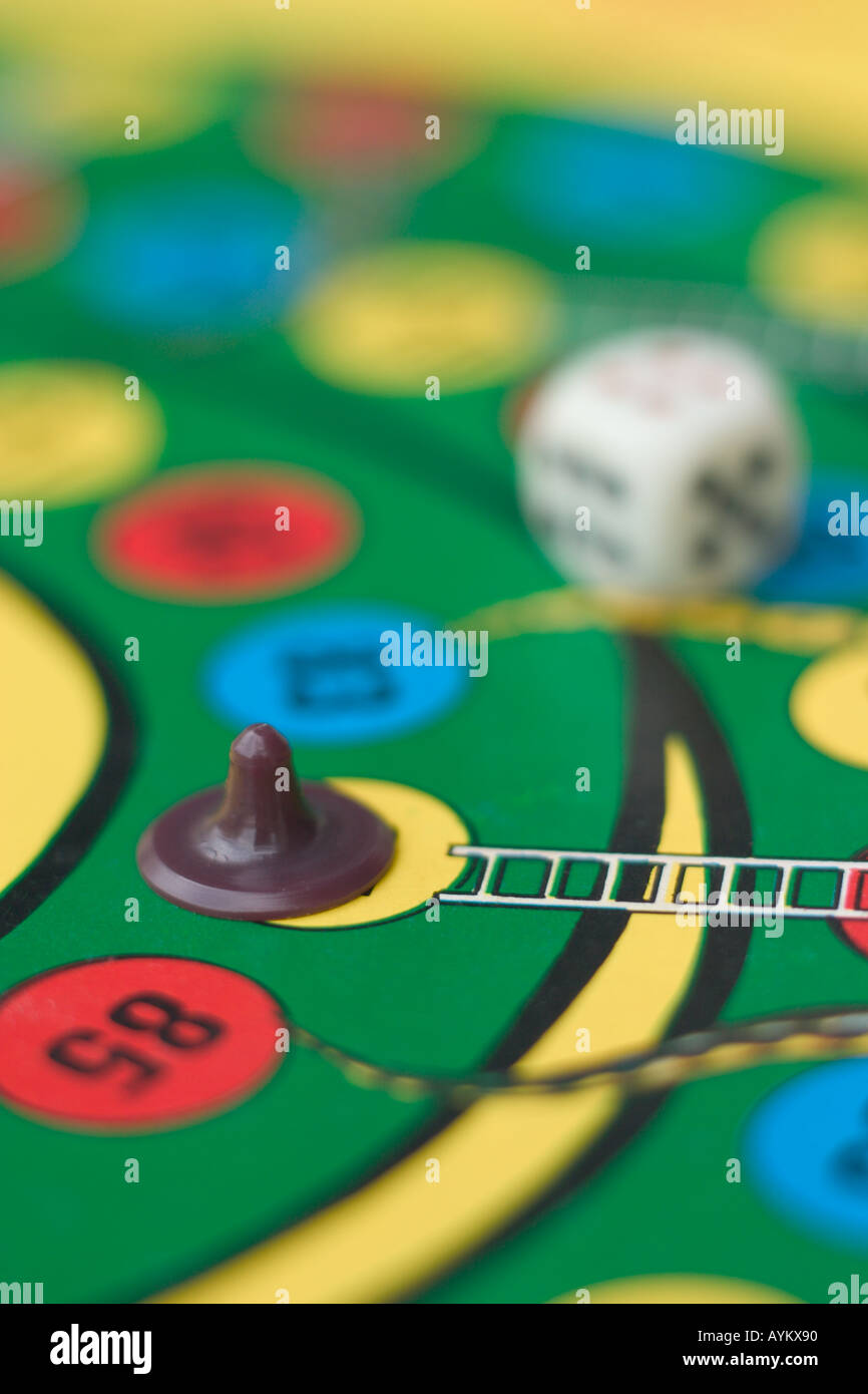 dice and piece on snakes and ladders board game Stock Photo Alamy