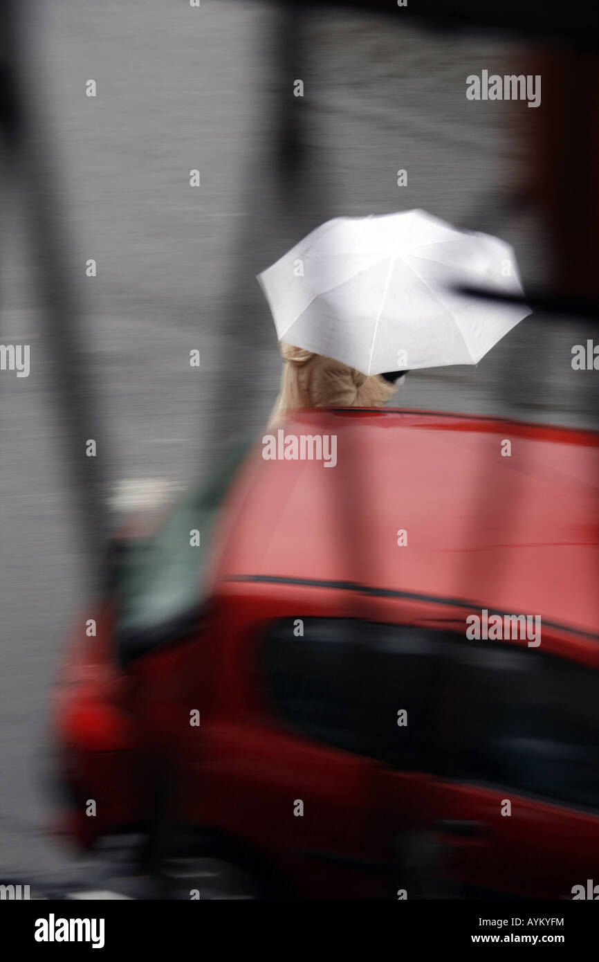 woman crossing road with umbrella in rain Stock Photo - Alamy