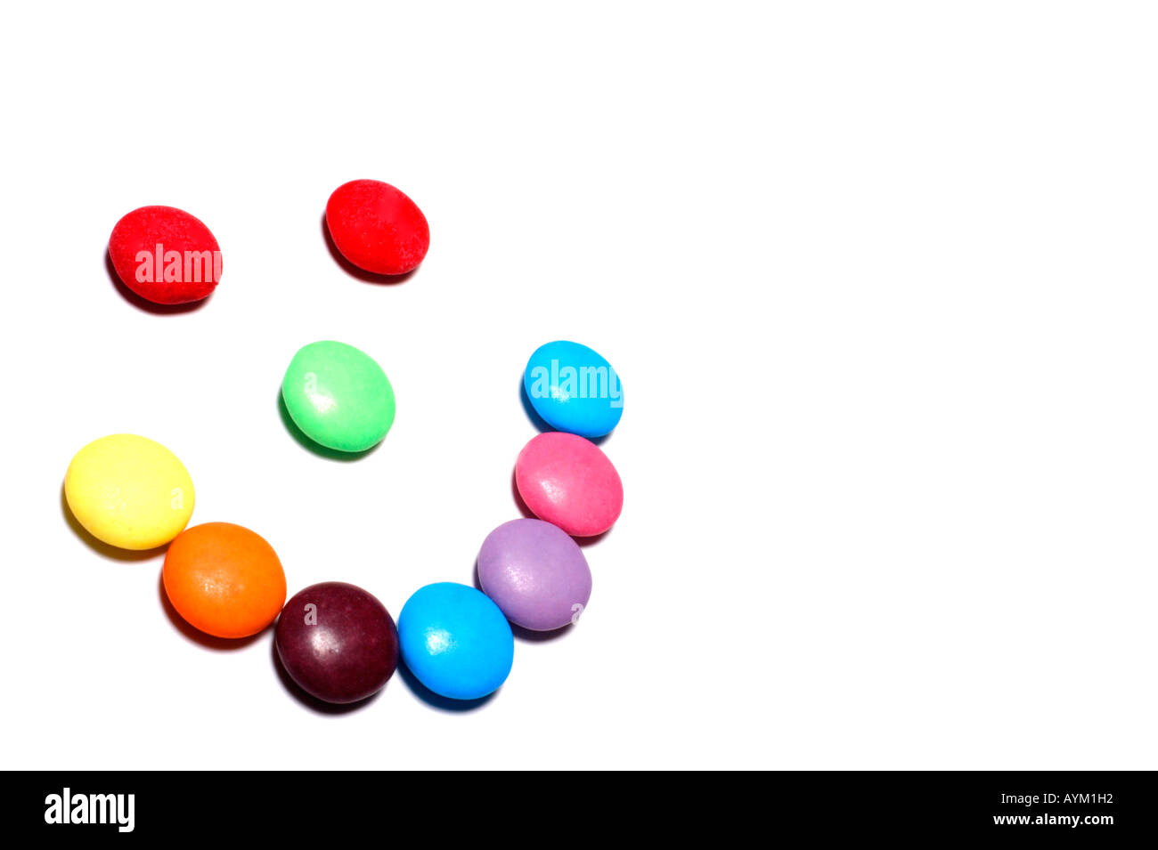 Colorful candy arranged in a smiley face on a white background with