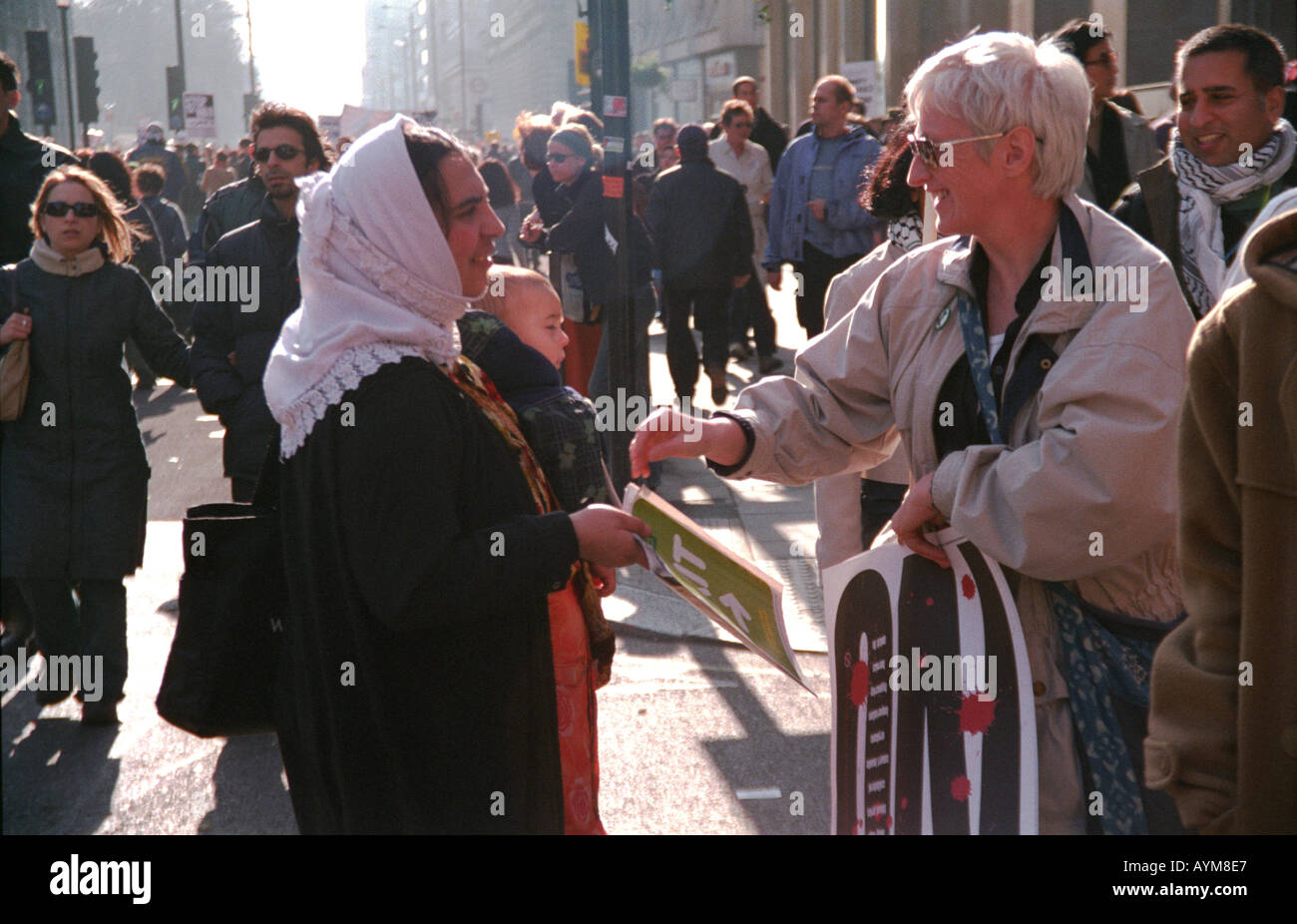 Demonstration against the war in Iraq in March 2003 in London Woman buying a Big Issue from a woman with a child in her arms Stock Photo