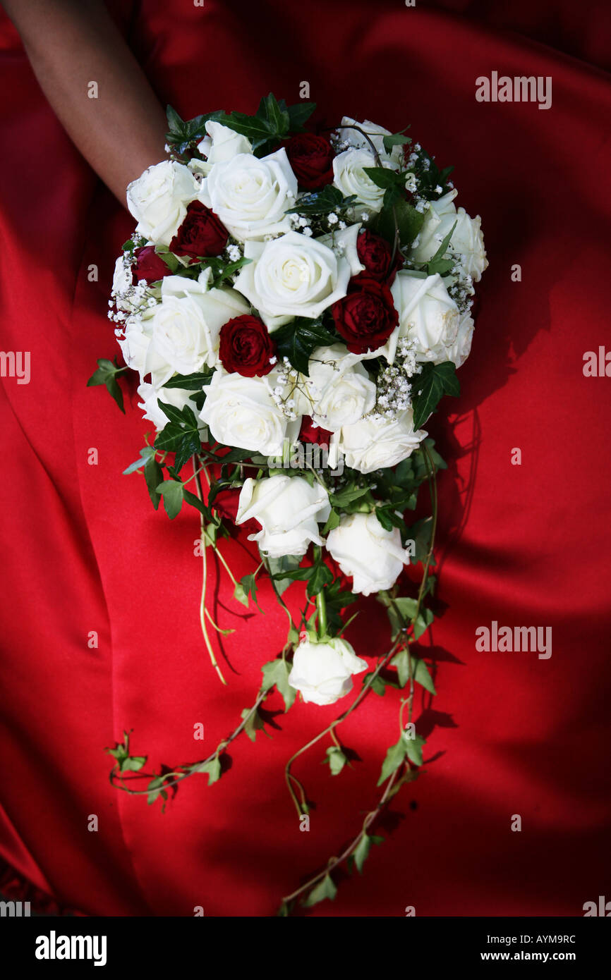 Bridal bouquet laying on red wedding dress Stock Photo - Alamy