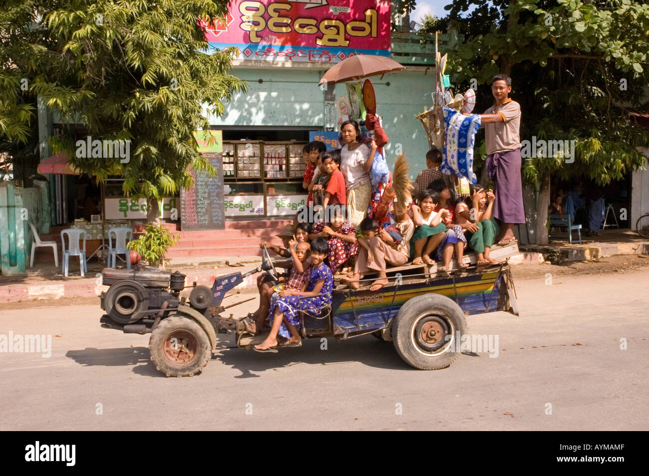 Stock photograph of a farm tractor carrying people and offerings in a street parade at Monywa in Myanmar 2006 Stock Photo