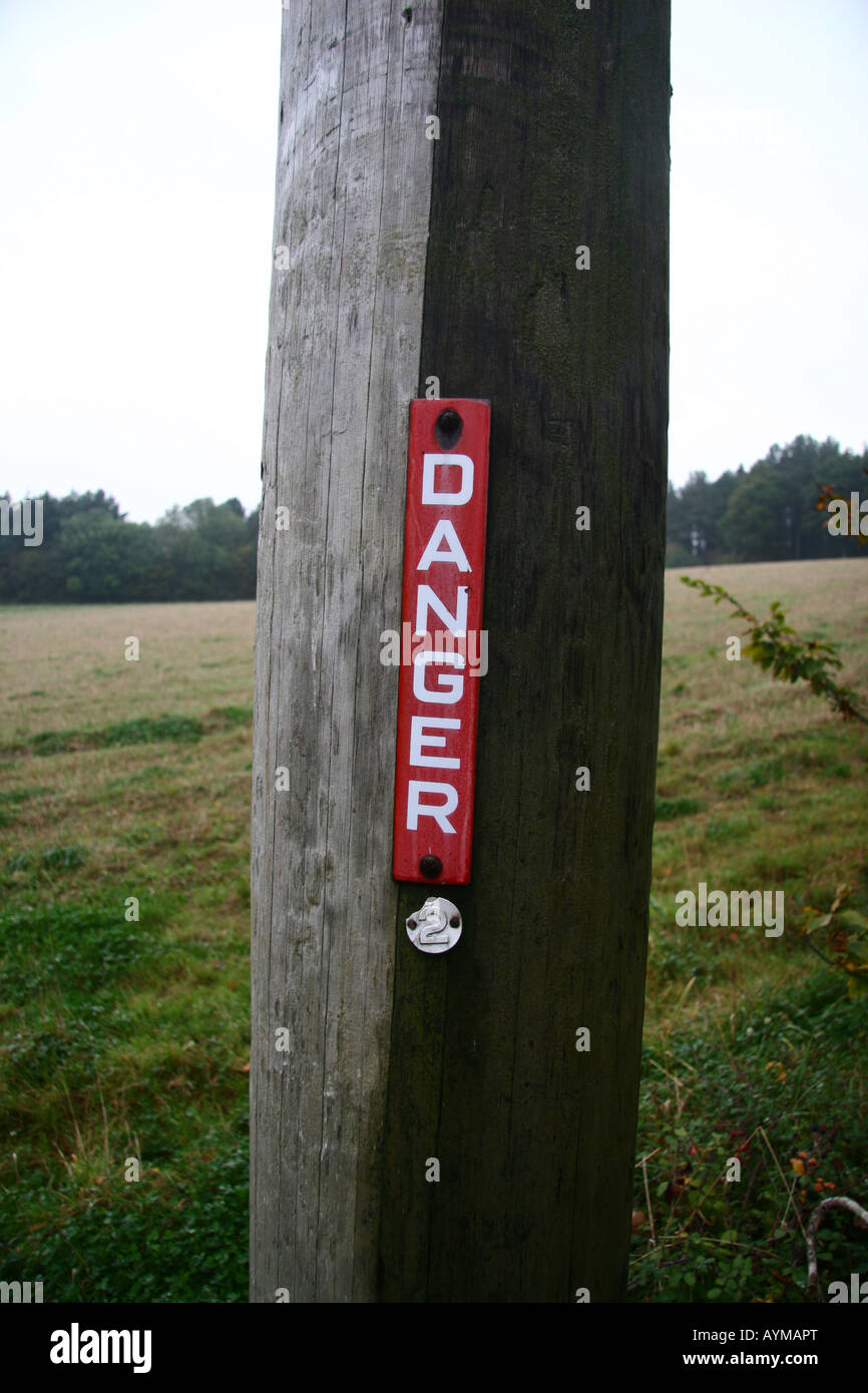 Danger sign on a power line post in field in the countryside Stock ...