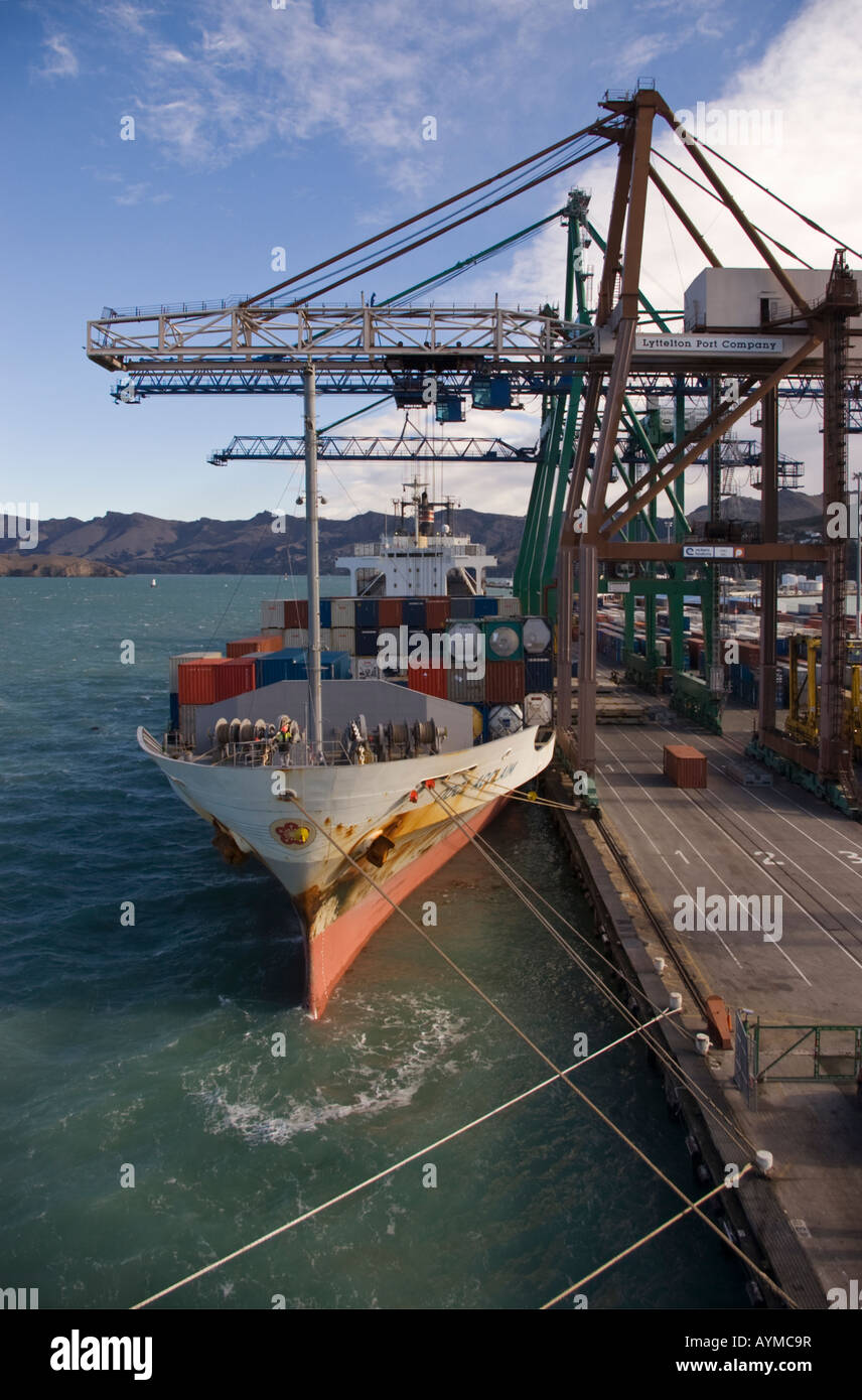 A container ship alongside the dock with shore cranes at work, Lyttelton, New Zealand Stock Photo