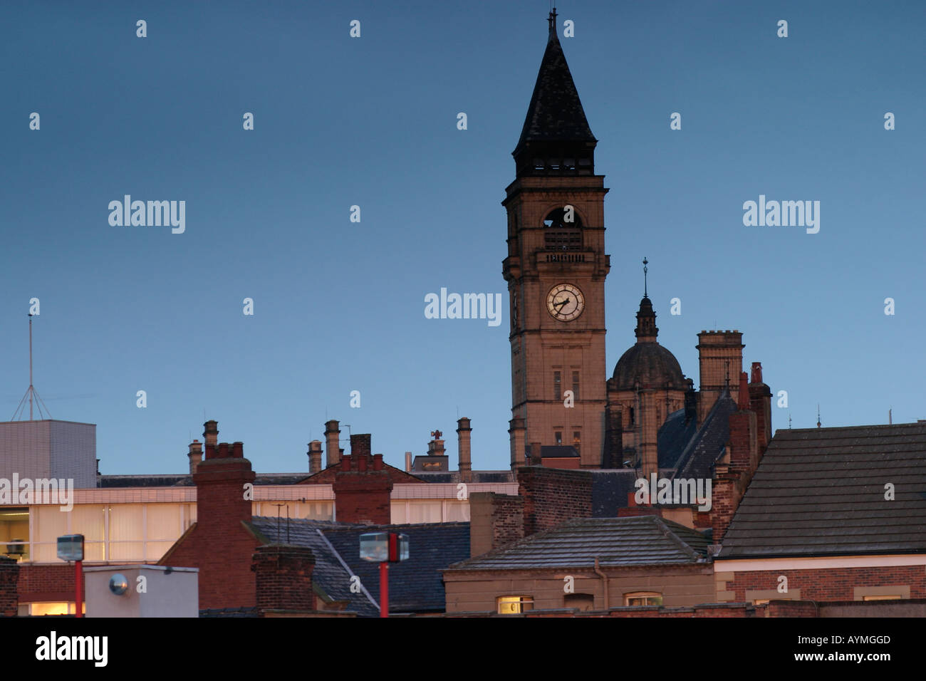Morning sun catches the clock tower of City Hall Wakefield with chimneys and roofs of adjacent offices in view Stock Photo