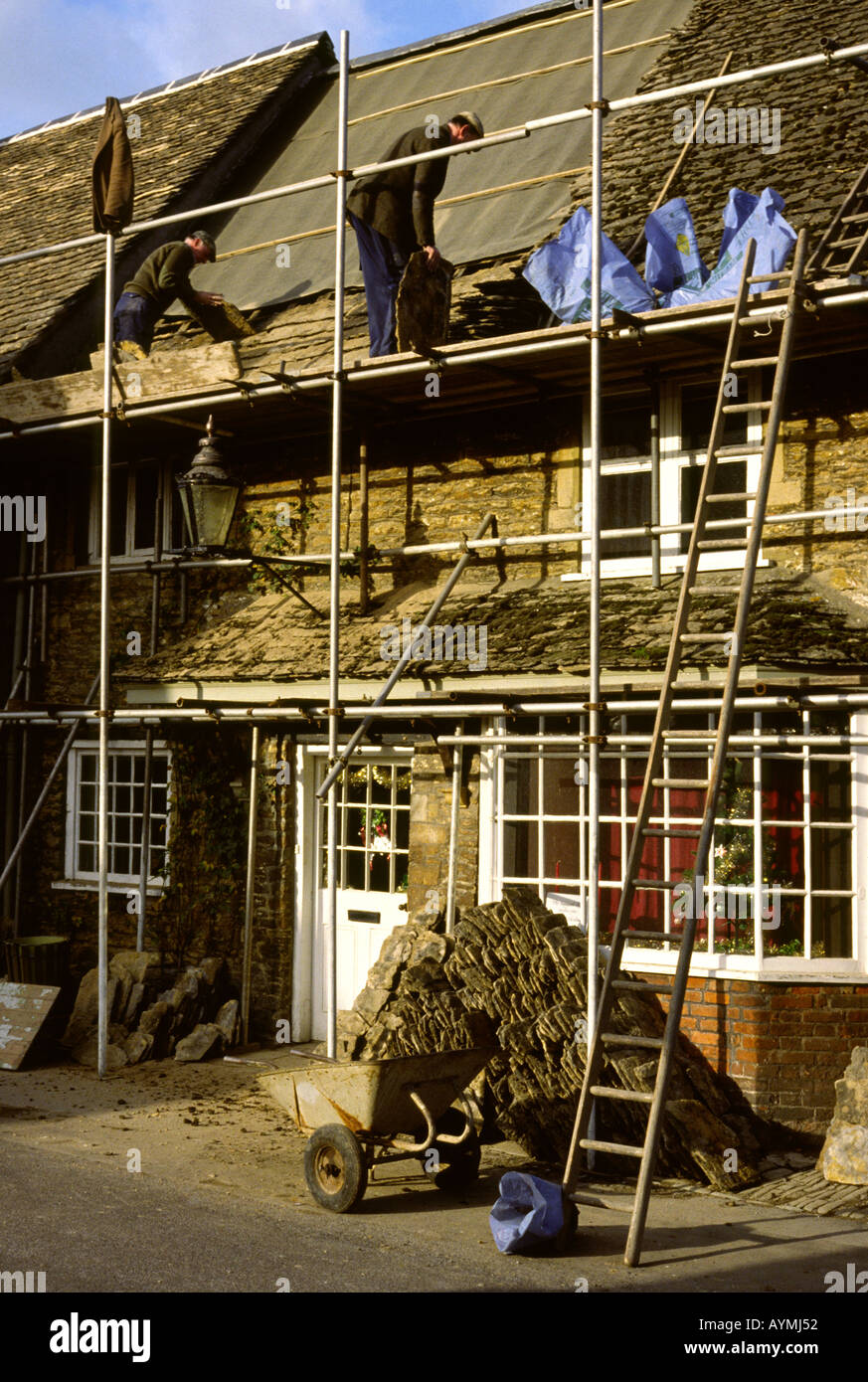 Construction builders re laying traditional stone flagged roof Stock Photo